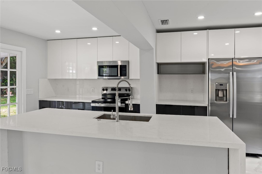 4970 Riverside Drive Estero, FL 33928 - Photo 16 of 35 a kitchen with stainless steel appliances a refrigerator sink and microwave