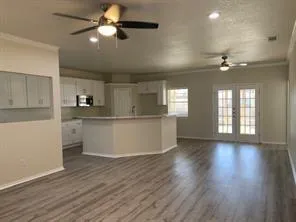 a view of an empty room with window and wooden floor