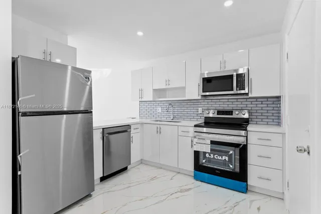 a kitchen with stainless steel appliances granite countertop a refrigerator stove and microwave