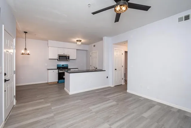 a view of kitchen with granite countertop cabinets and refrigerator