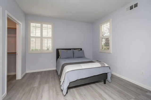 a bed sitting in a bedroom next to a window