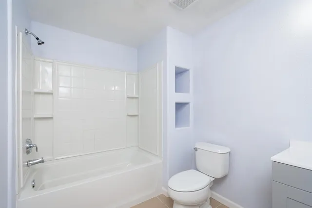 a white toilet sitting next to a bath tub