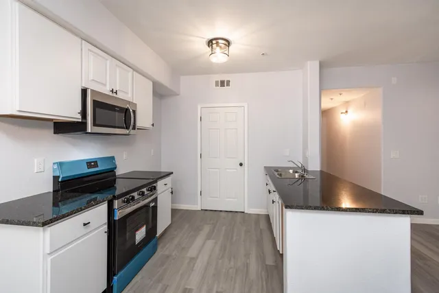 a kitchen with granite countertop a stove and a microwave