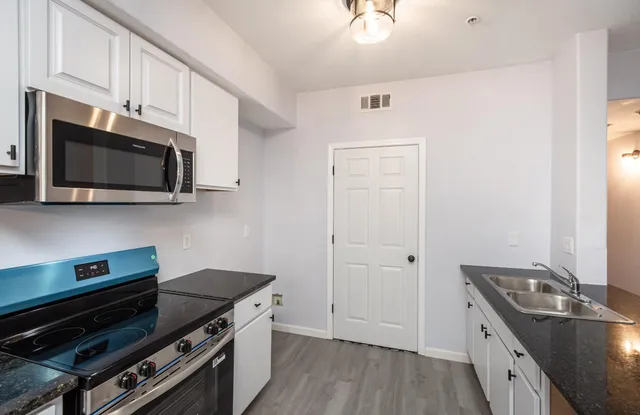 a kitchen with stainless steel appliances a stove microwave and sink