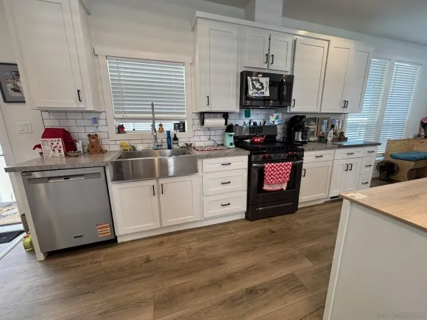 a kitchen with stainless steel appliances granite countertop a stove sink and cabinets