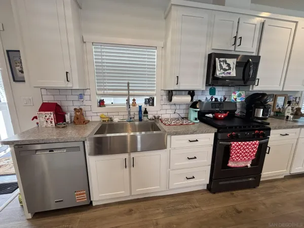a kitchen with stainless steel appliances granite countertop a stove a sink and a microwave