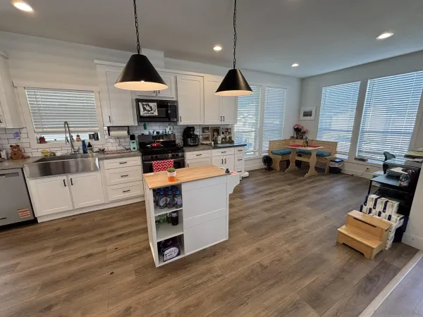 a kitchen with stainless steel appliances granite countertop a stove and a wooden floors