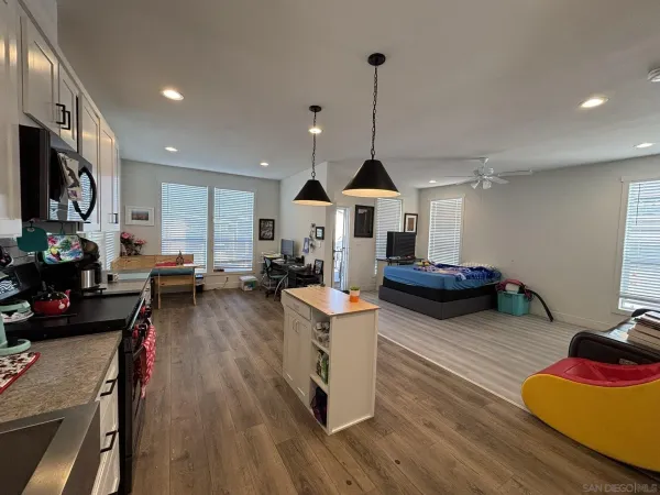 a view of a living room and kitchen with furniture wooden floor