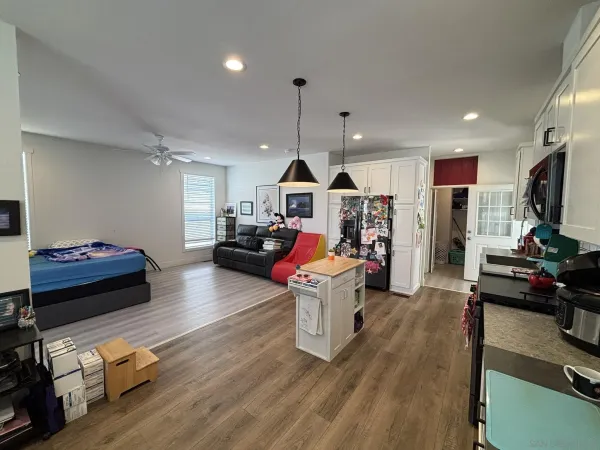 a living room with furniture flat screen tv and a chandelier