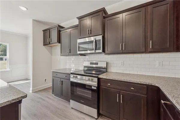 a kitchen with granite countertop wooden cabinets and stainless steel appliances