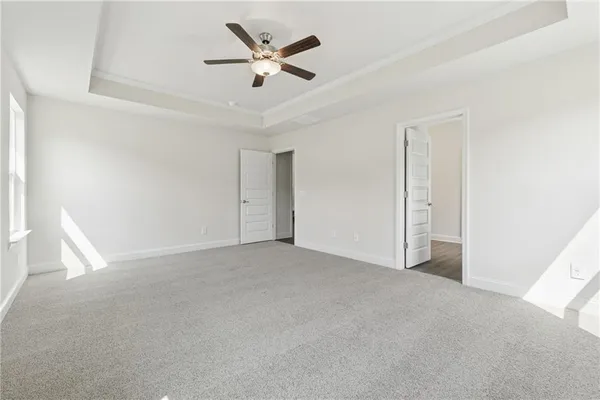 an empty room with ceiling fan and window