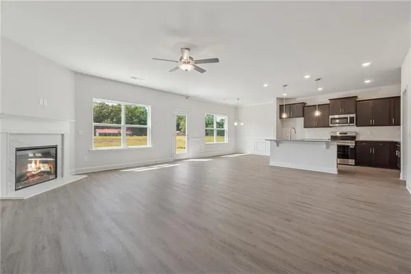a view of a big room with wooden floor and a kitchen