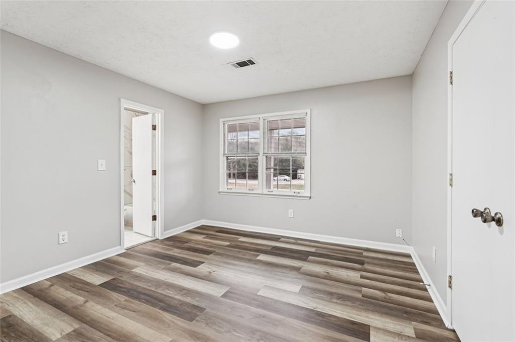 5151 Lilburn Stone Mountain Road Lilburn, GA 30047 - Photo 24 of 58 a view of a room with wooden floor and window