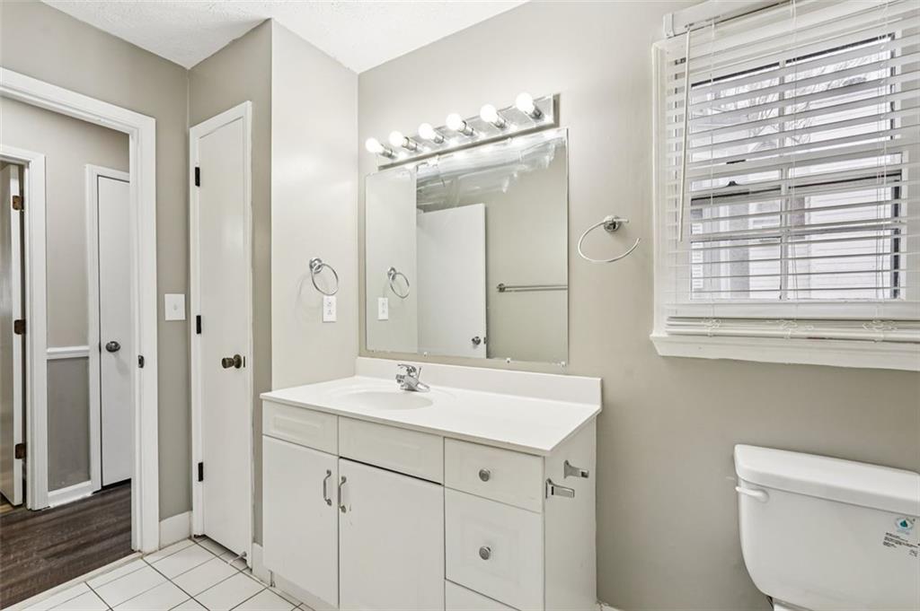 5151 Lilburn Stone Mountain Road Lilburn, GA 30047 - Photo 27 of 58 a bathroom with a sink a light fixture and a mirror