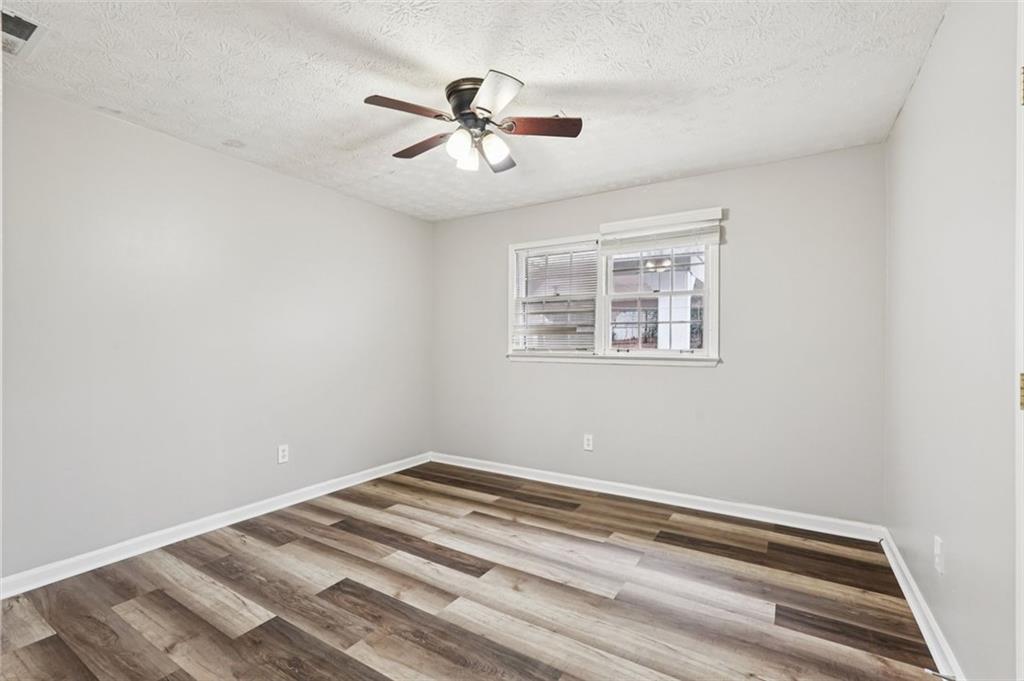 5151 Lilburn Stone Mountain Road Lilburn, GA 30047 - Photo 30 of 58 a view of a big room with wooden floor and windows