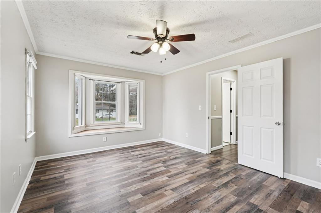 5151 Lilburn Stone Mountain Road Lilburn, GA 30047 - Photo 36 of 58 a view of an empty room with wooden floor and a window
