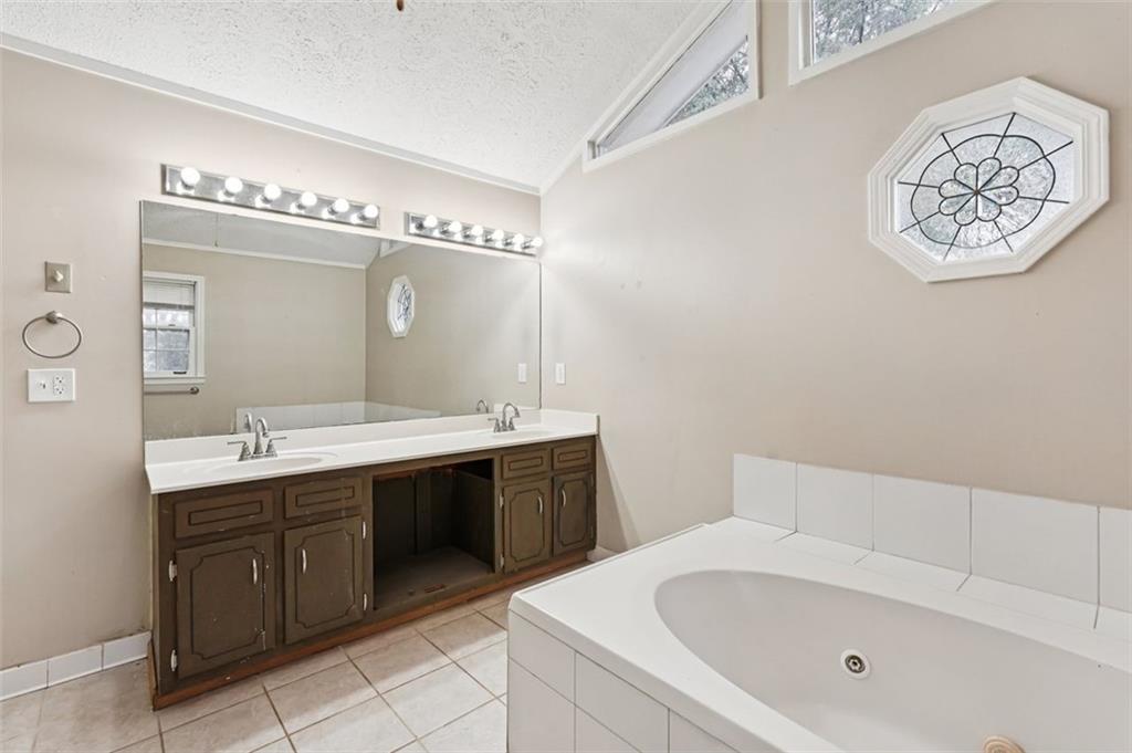 5151 Lilburn Stone Mountain Road Lilburn, GA 30047 - Photo 41 of 58 a bathroom with a bathtub sink and mirror
