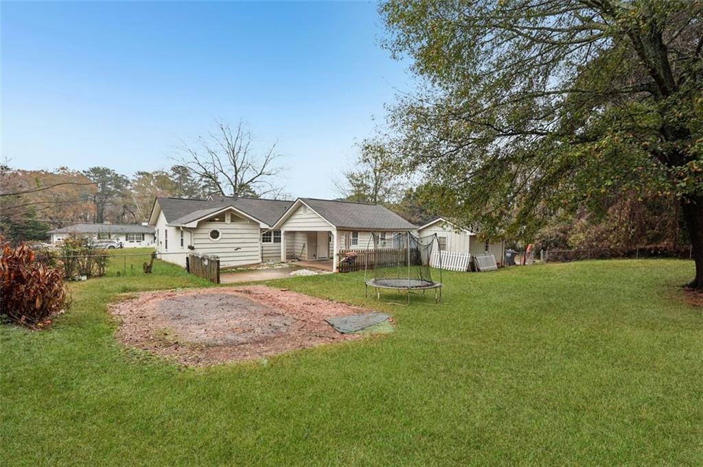5151 Lilburn Stone Mountain Road Lilburn, GA 30047 - Photo 55 of 58 a front view of a house with a garden and trees