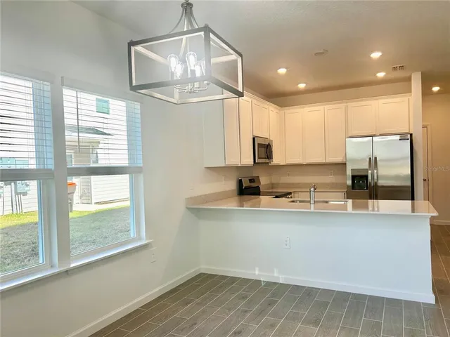 a view of a kitchen with a sink and a refrigerator