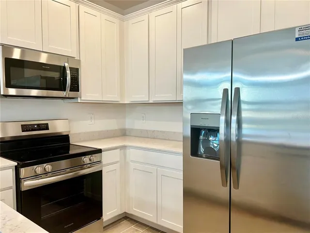 a kitchen with stainless steel appliances granite countertop a sink a stove and a microwave
