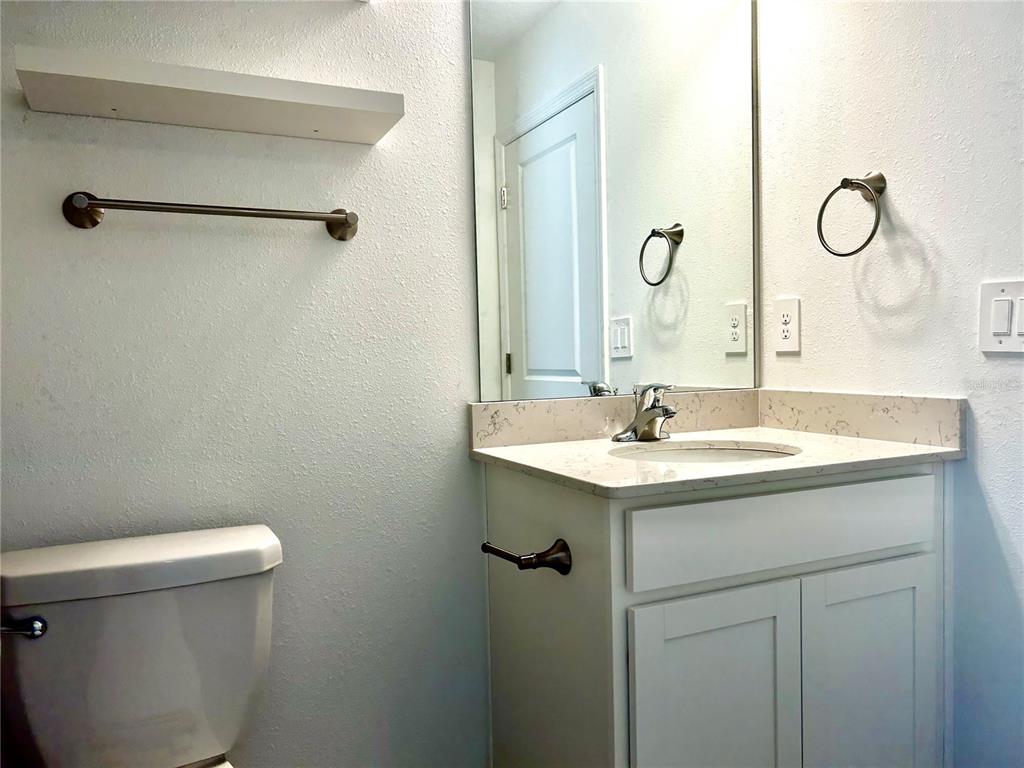 3514 Southeast 37th Ave Road Ocala, FL 34480 - Photo 30 of 42 a bathroom with a granite countertop sink a toilet and a mirror