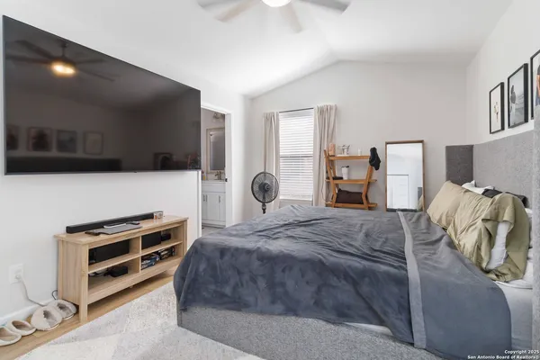 a bedroom with a bed and a flat tv screen on the dresser