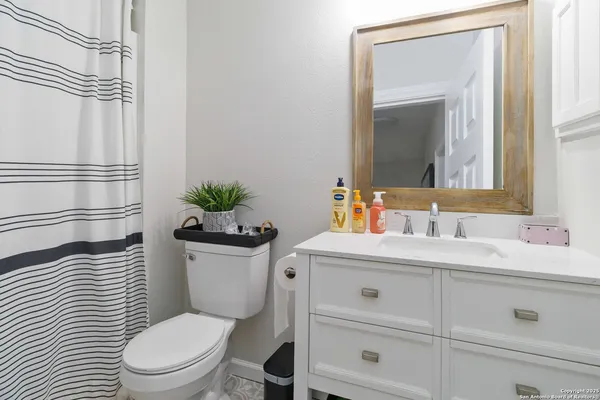 a bathroom with a toilet a sink and a mirror