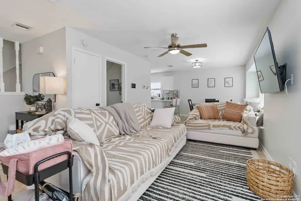 a spacious bedroom with a bed a couch and a chandelier