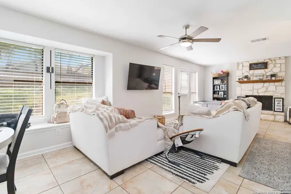 a living room with furniture a flat screen tv and a large window