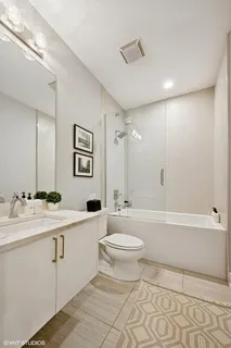 a bathroom with a double vanity sink toilet mirror and bathtub