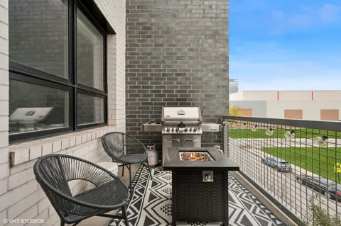 a table and chairs sitting on a balcony with a yard