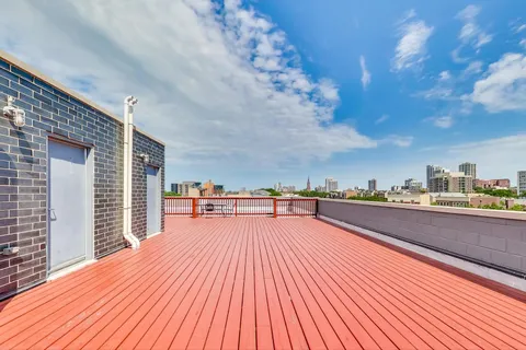 a view of a balcony with wooden floor and fence