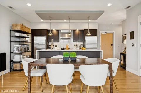 a view of kitchen with stainless steel appliances kitchen island dining table and chairs