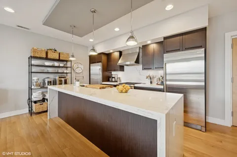 a kitchen with kitchen island a sink stainless steel appliances and cabinets