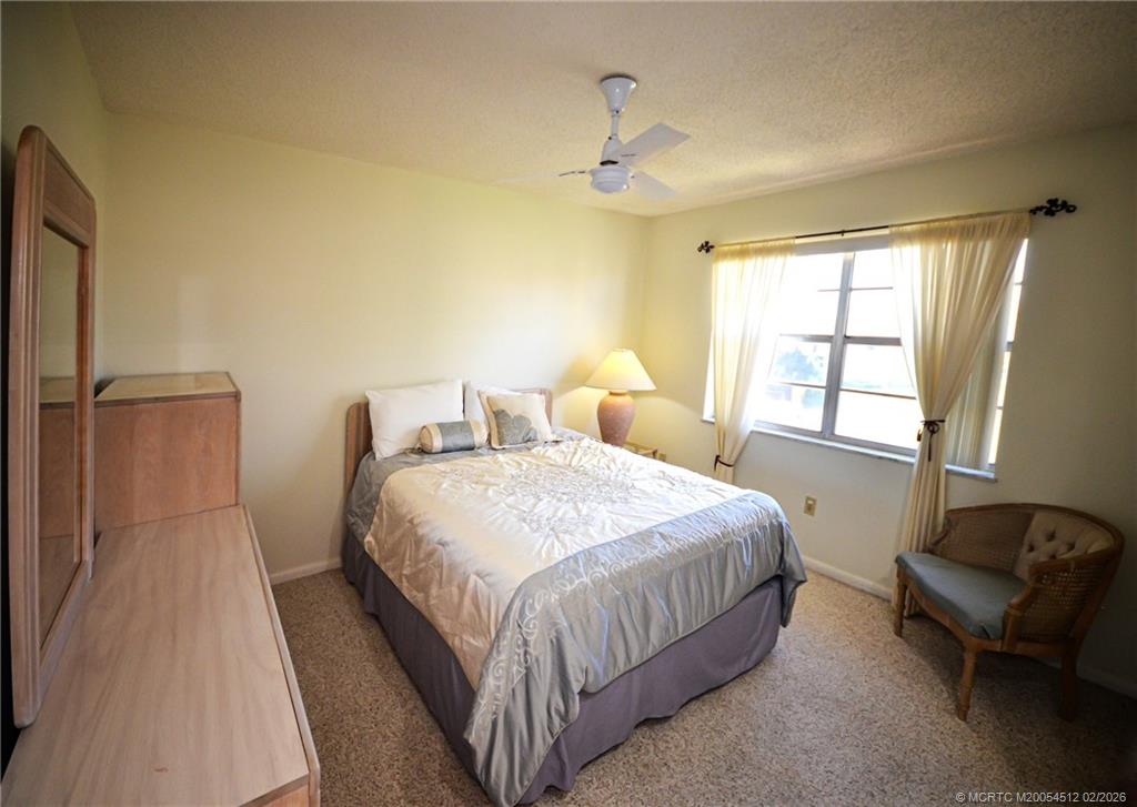 1963 Southwest Palm City Road, Unit F Stuart, FL 34994 - Photo 17 of 19 a bedroom with a bed chair and window