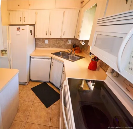 a view of a kitchen with a sink washer and dryer