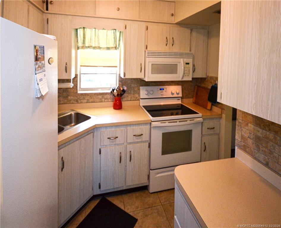 1963 Southwest Palm City Road, Unit F Stuart, FL 34994 - Photo 5 of 19 a kitchen with cabinets appliances and a window