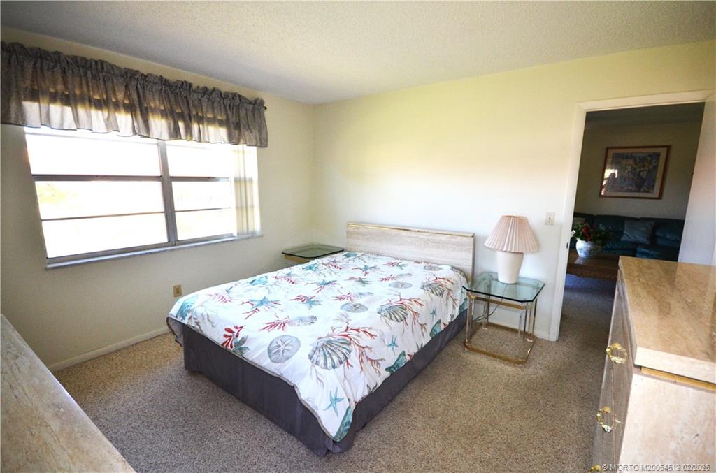 1963 Southwest Palm City Road, Unit F Stuart, FL 34994 - Photo 7 of 19 a bedroom with a bed wooden floor and window