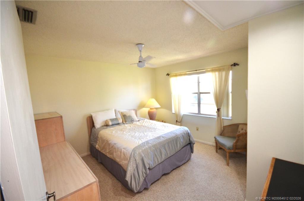 1963 Southwest Palm City Road, Unit F Stuart, FL 34994 - Photo 9 of 19 a bedroom with a bed and a window