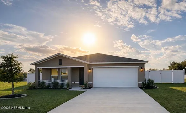 a front view of a house with a garden and yard