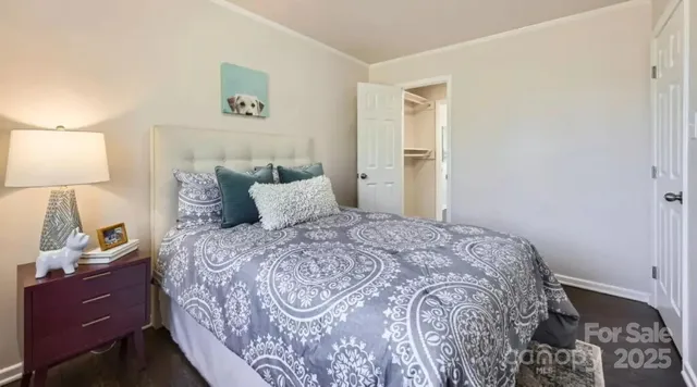 a bedroom with a bed and a lamp on the dresser