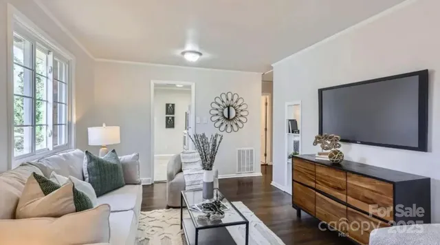 a living room with furniture a window and a flat screen tv