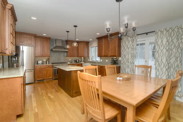 a kitchen with kitchen island a white counter top space a sink appliances and cabinets