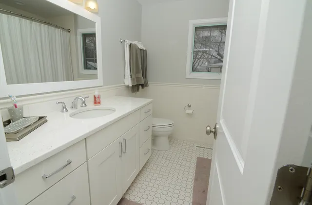 a bathroom with a sink a toilet and a mirror