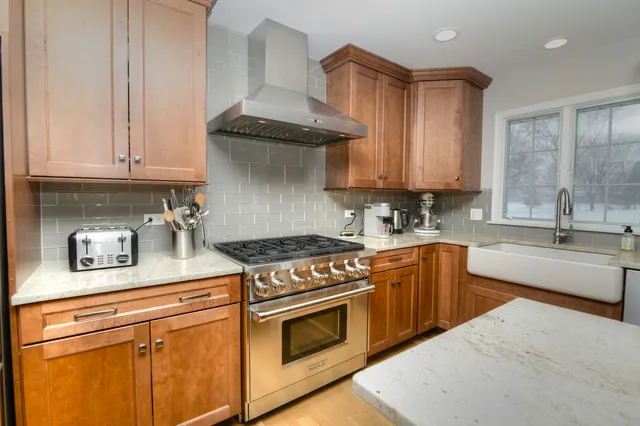 a kitchen with stainless steel appliances granite countertop a sink stove and cabinets