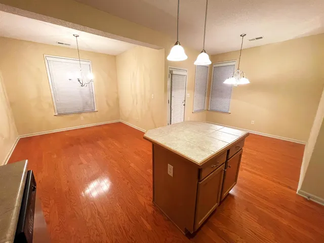 a kitchen with a wooden floor and a chandelier