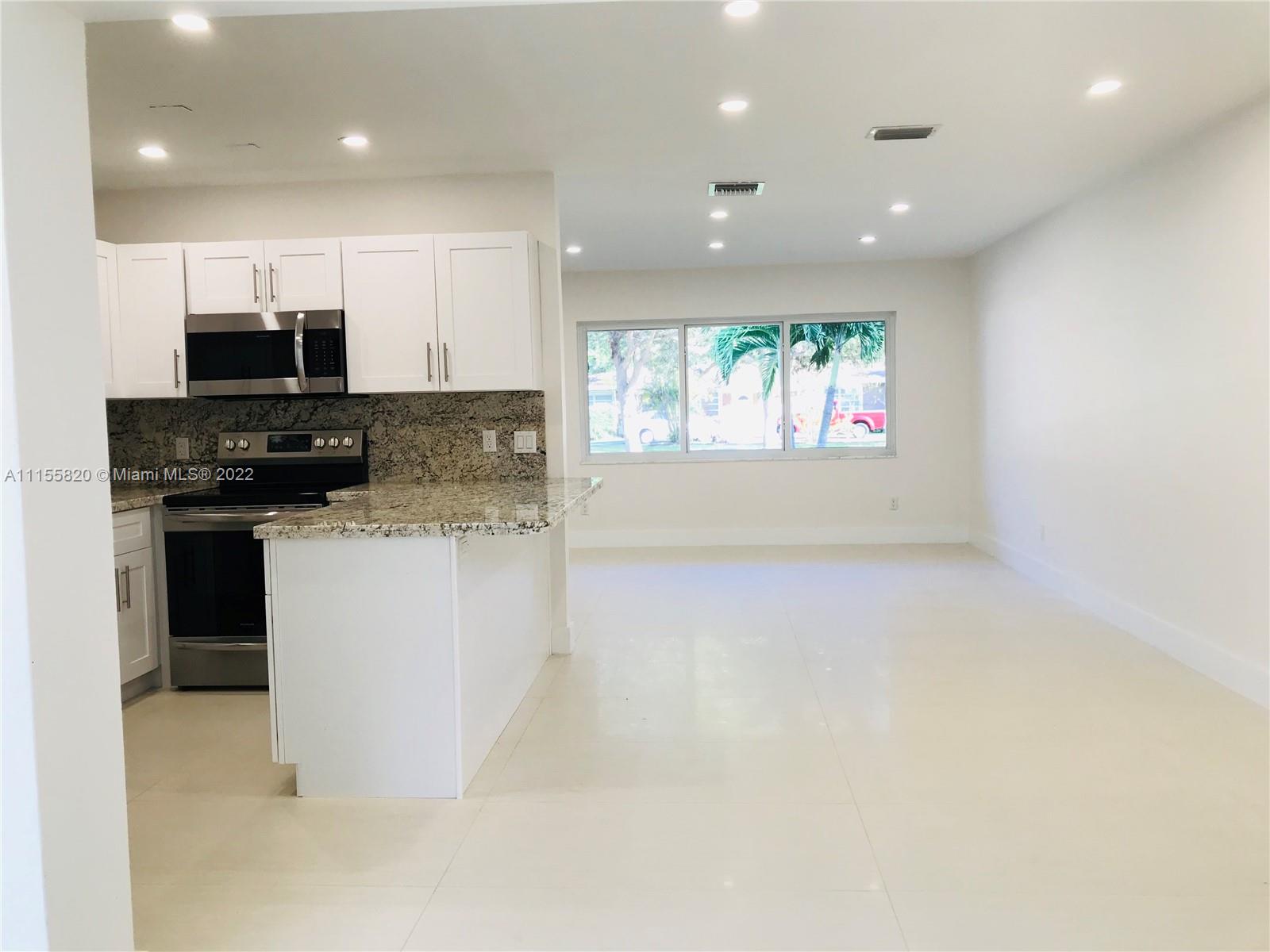 11720 Southwest 81st Road, Unit 11720 Pinecrest, FL 33156 - Photo 11 of 33 a kitchen with stainless steel appliances granite countertop a stove a sink and a microwave