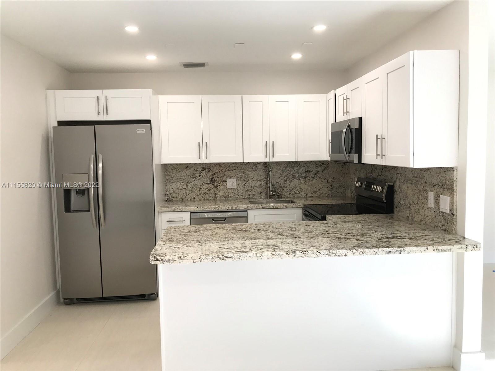 11720 Southwest 81st Road, Unit 11720 Pinecrest, FL 33156 - Photo 30 of 33 a kitchen with stainless steel appliances granite countertop a refrigerator a stove and a sink