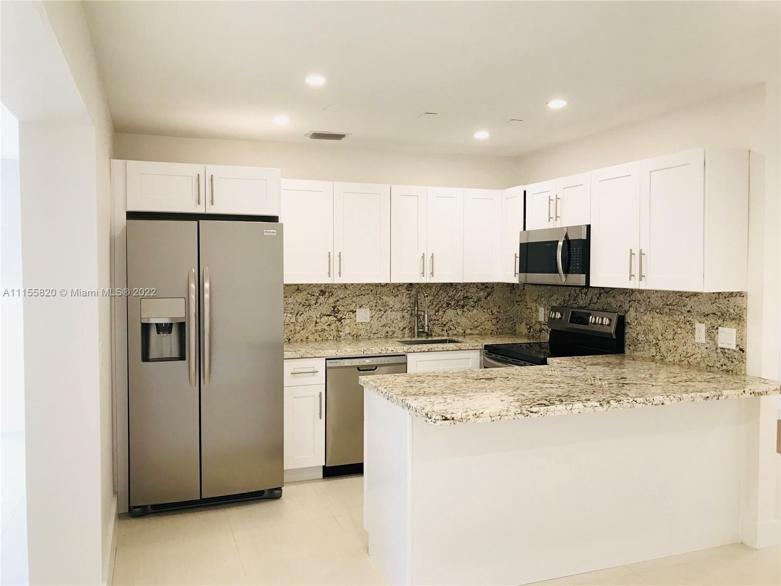 11720 Southwest 81st Road, Unit 11720 Pinecrest, FL 33156 - Photo 4 of 33 a kitchen with a refrigerator a microwave a sink and a stove