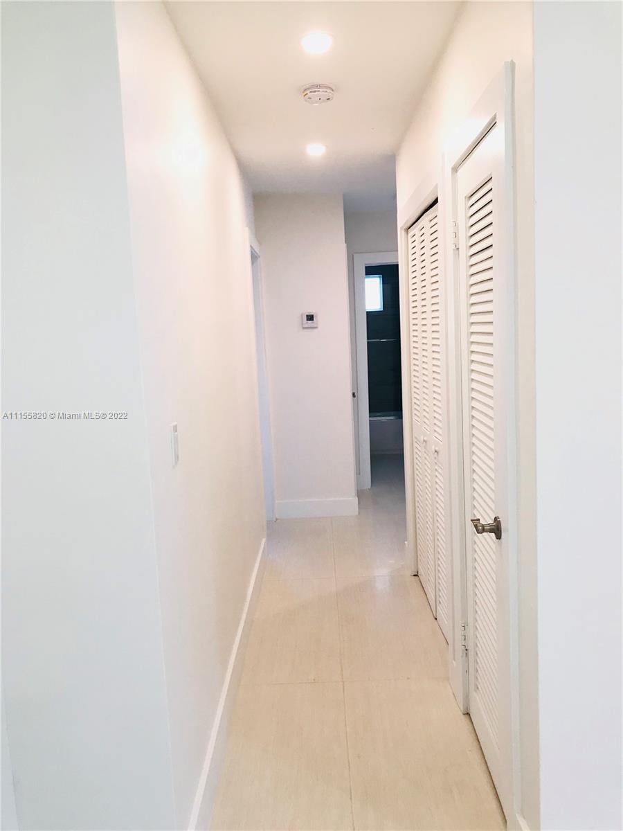 11720 Southwest 81st Road, Unit 11720 Pinecrest, FL 33156 - Photo 5 of 33 a view of a hallway with closet and bathroom